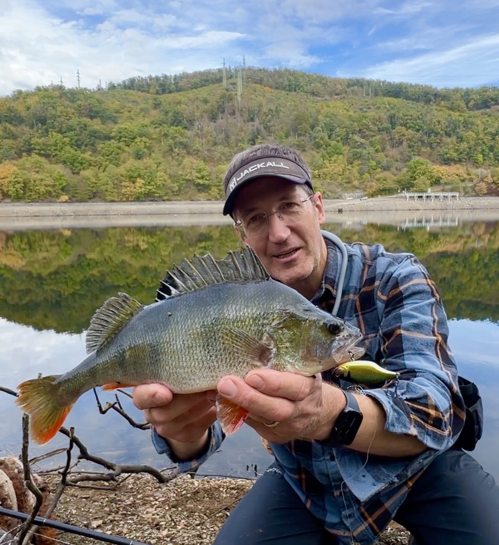 Oleg holding a big perch caught on a lure at a reservoir near Prague